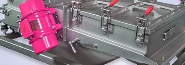 Industrielle Siebmaschine mit roten Verschlusshaken und einem rosafarbenen Kompressor dazwischen.