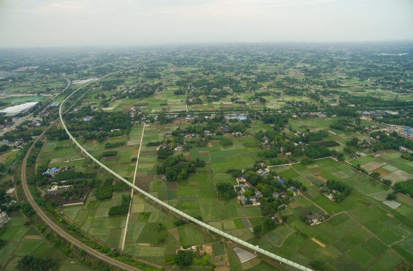 Landschaft mit einem sehr langen überdachten Gurtförderband aus der Flugzeugperspektive