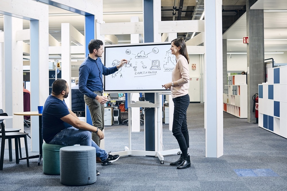 Mitarbeiter der E+H stehen im Büro vor einem Whiteboard und malen Skizzen zur Digital Solution