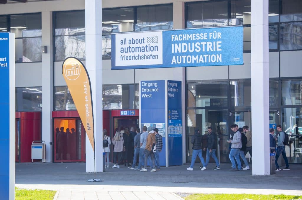 Eingang der Automationsmesse all about automation in Friedrichshafen mit Publikum auf schuettgutmagazin