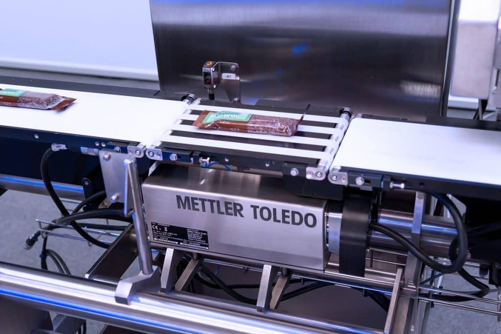 Mettler Toledo FlashCell-Wägetechnologie verpacktes Lebensmittel wird im Herstellungsprozess gewogen, auf schuettgutmagazin.de