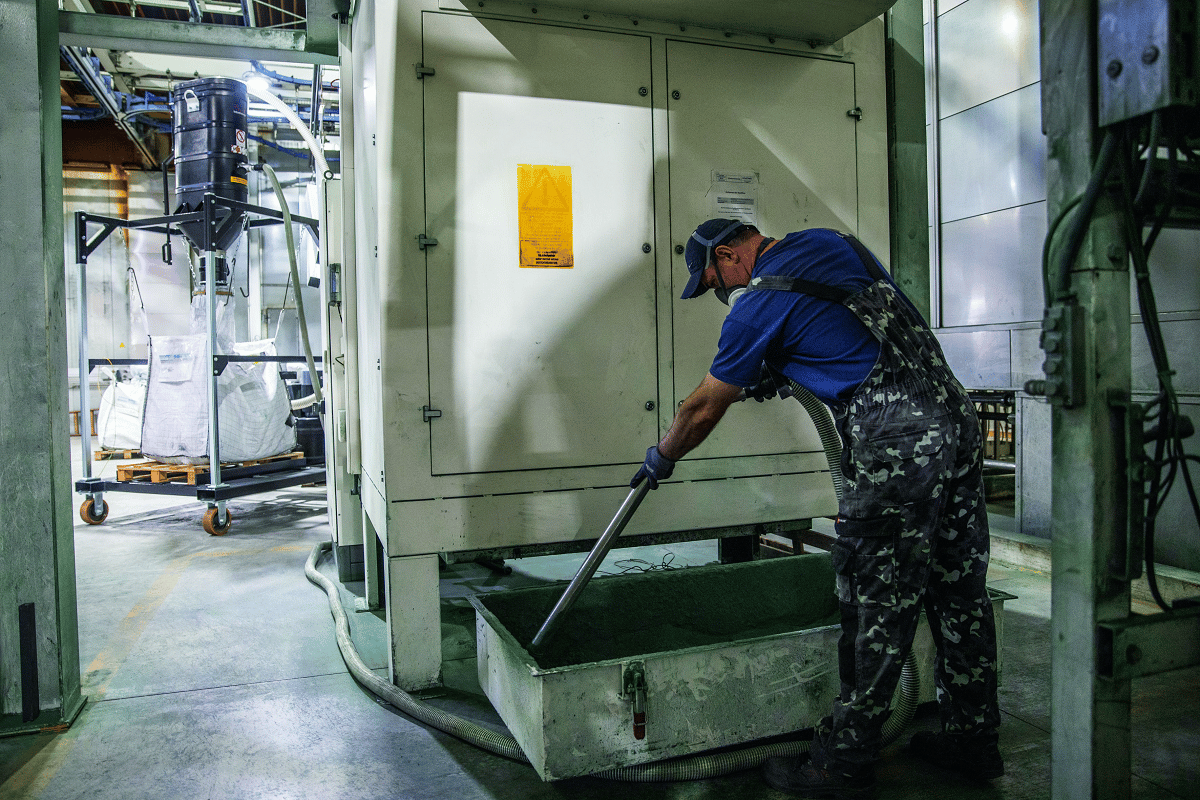 Mitarbeiter in einer Werkshalle saugt mit einem Ruwac Sauger einen Filterkasten aus, auf schuettgutmagazin.de