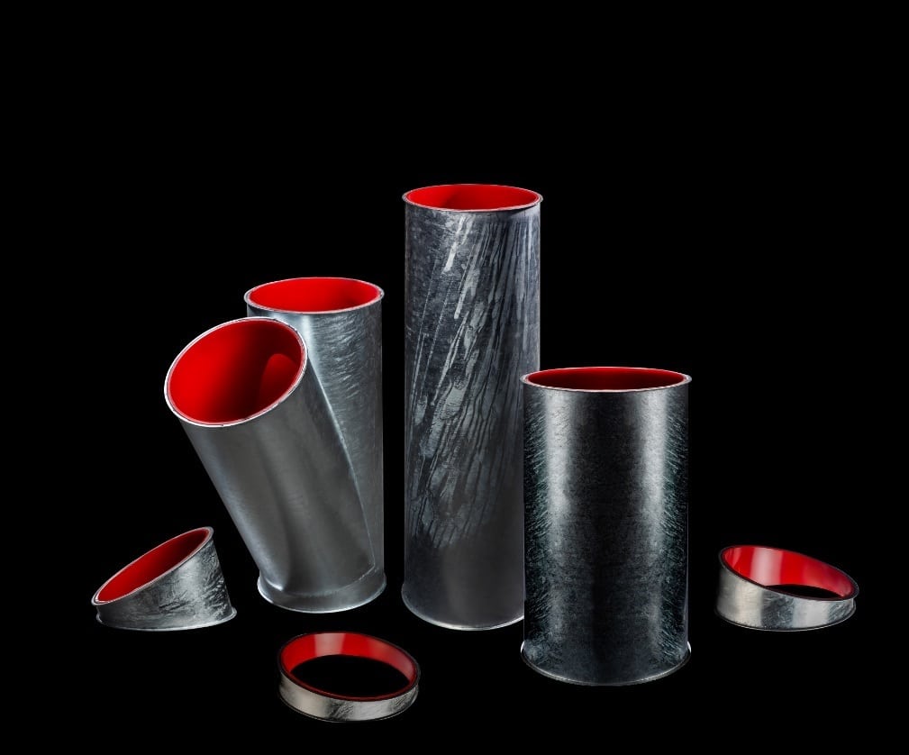 Verschiedene Rohrelement der Noro Gesellschaft für Rohrsysteme mit innen aufgebrachter roter Verschleißschutz-Auskleidung. Rohrelemente in schmal, breit, mit Verteilrohr und Flanschen