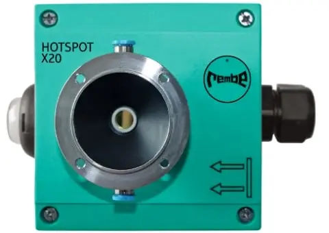 Grüner Meldesensor Hotspot X20 der Rembe GmbH Safety & Control. Quadratischer Kasten mit Anschluss in der sichtbaren Front, links einem Lichtzeichen, rechts einem weiteren Anschluss. An allen vier Ecken sind Kreuzschlitz-Schrauben. Das Logo der Rembe ist rechts in Schwarz aufgebracht, darunter zwei Pfeile, die waagerecht nach links zeigen und durch eine Linie begrenzt sind, die senkrecht nach oben geht