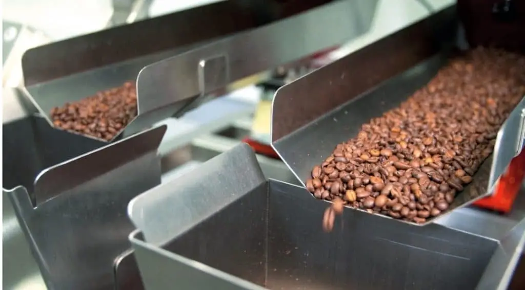 Zwei Schienen auf denen Kaffee gerüttelt wird und in einen davor liegenden nach unten führenden Schacht transportiert wird