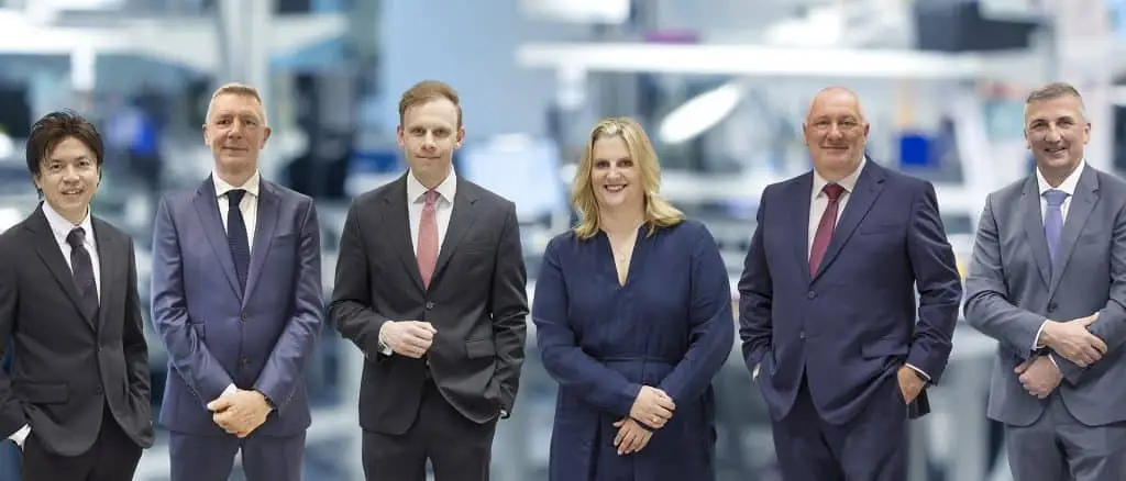 Das C-Level von Minebea Intec (v.l.): COO Munetaka Nakazawa, CPO Peter Grimley, CEO Dr. Karl Sommer, CFO Manina Kettler, CSO Nick Parsons, CTO Dr. Axel Böttger stehen in einer Reihe nebeneinander