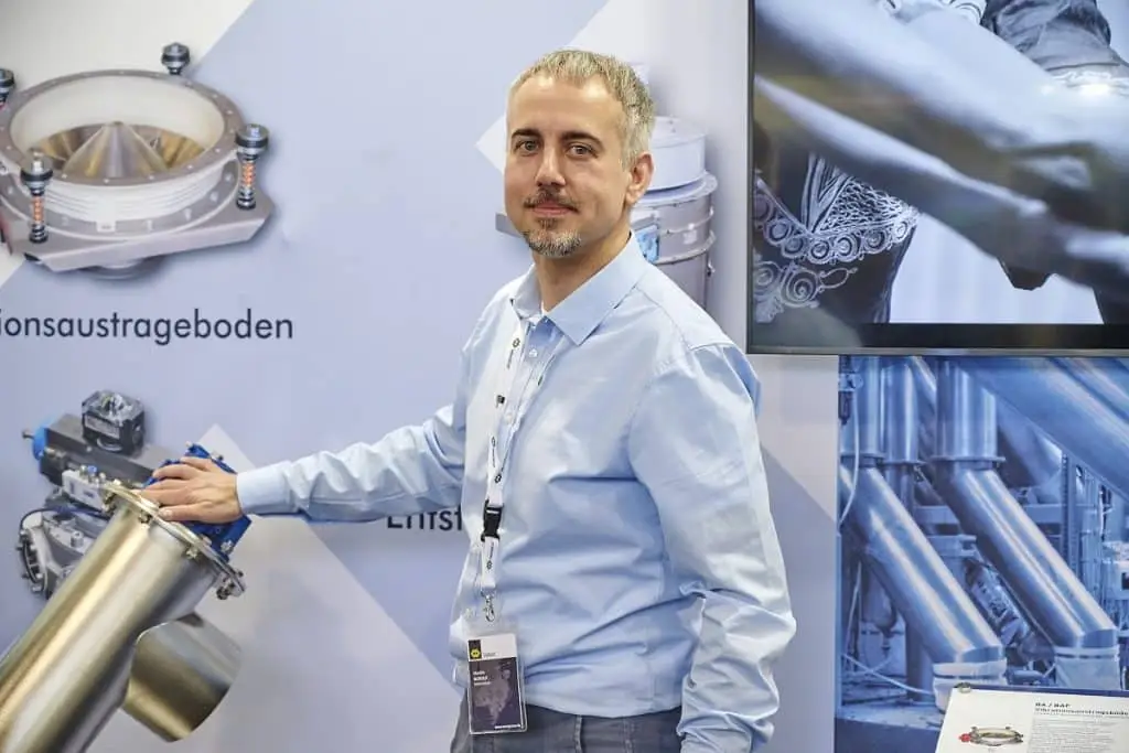 Martin Rudolf der WAM vor einer Messewand während der Solids 2023