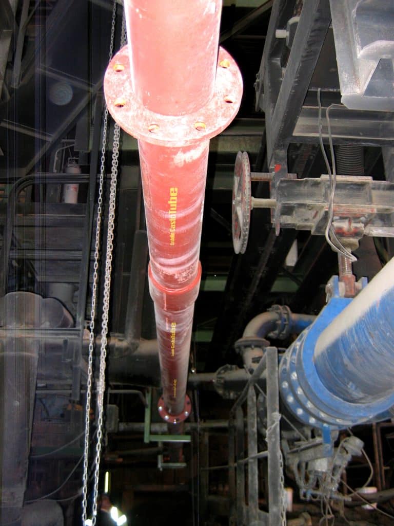 Zement transportierendes rotes Rohr von Castolin Eutectic in einer Produktionshalle.