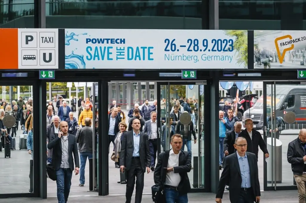 Besucher strömen unter einem Schild Save the Date Powtech 26.-28.09.2023 Nürnberg, Germany in die Messehalle. Copyright Nürnberg Messe- Heiko Stahl
