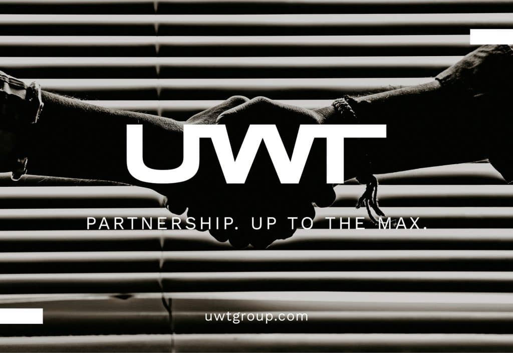 Vor vielen Leitungen in schwartz weiß zwei Männerhände mit Unterarm die sich die Hand geben. Darüber das neue UWT Logo und er Slogan Partnership. Up to the Max. uwtgroup.com