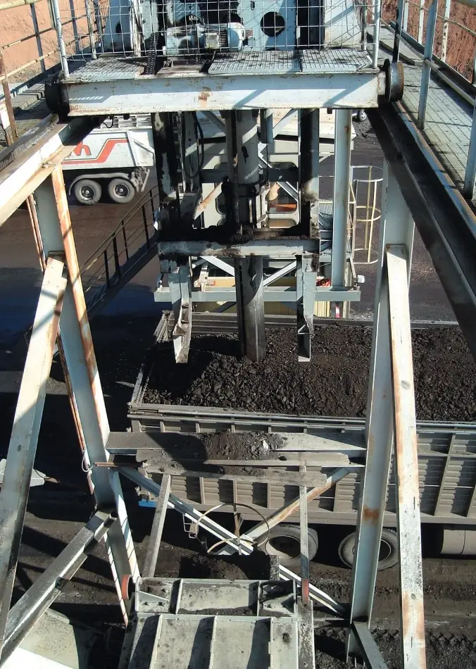 Beprobungssituation mit einer Bohrschnecke von Oben. Man blickt in den LKS, und das Ror der Bohrschnecke ist im braunen Schüttgut.