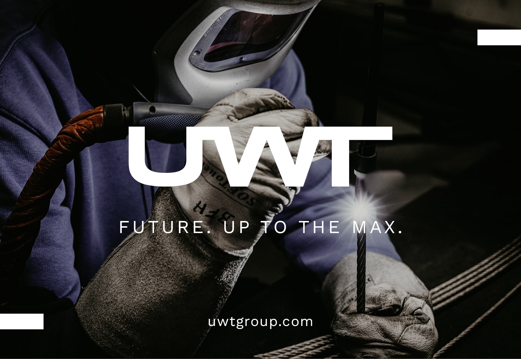UWT Logo groß in der Mitte. Im Hintergrund ein Schweißer mit Handschuhen, Brille und einem Metallstrang und Schweißstahl. Unter dem Logo Future. Up to the max. und uwtgroup.com