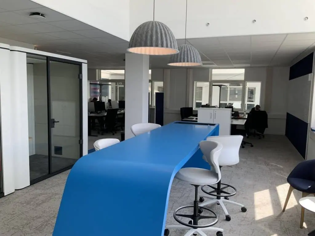 Blauer moderner Tisch mit Drehhochstühlen.
