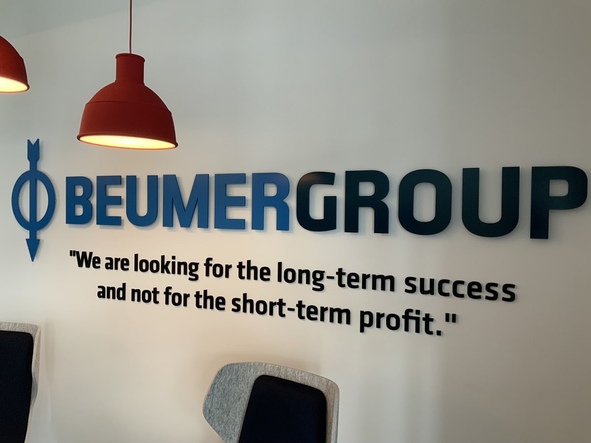 Wand in Beumer Büro Dortmund. Auf der Wand steht Beumer Group und darunter "We are looking for the long-term success and not for the short-term profit."