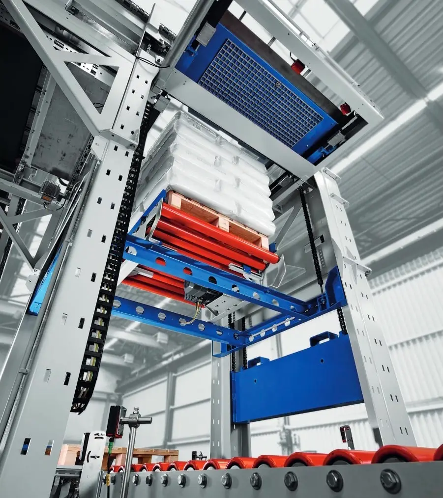 Palletiergerät, unten rote Rollen, darüber eine Konstruktion auf der auf weiteren Rollen eine Europalette steht, auf den Zementsäcken liegen. Diese Vorrichtung ist höhenverstellbar. Die Säcke auf der Europalette werden mit Folie umpackt.
