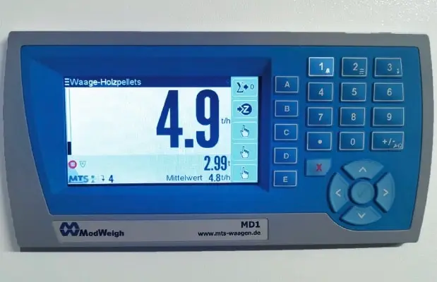 Bildschirm und Tastatur eines Auswertesystems einer E-Waage für Holzpellets. Links das Display, rechts Knöpfe ABCDE, 1-0 ,* +/- und ein x ebenso ein kreisrunder Knopf umrundet mit 1⁄4 Rundungen, mit Pfeil in alle Himmelsrichtungen.