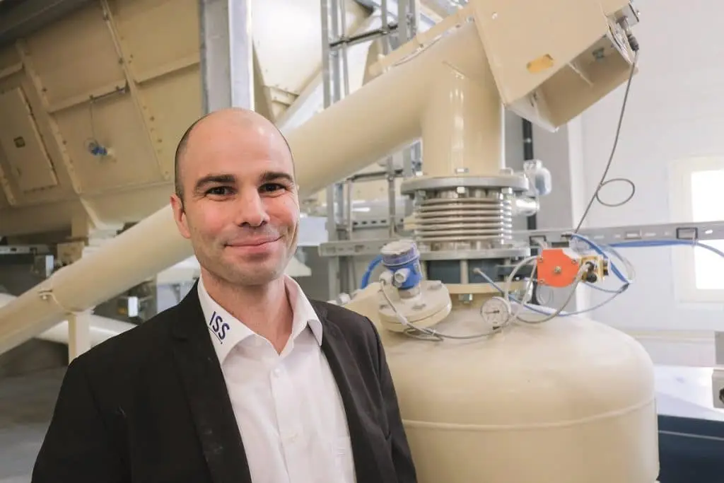 Robert Partzsch, vor einer Förderanlage in einer Industriehalle.