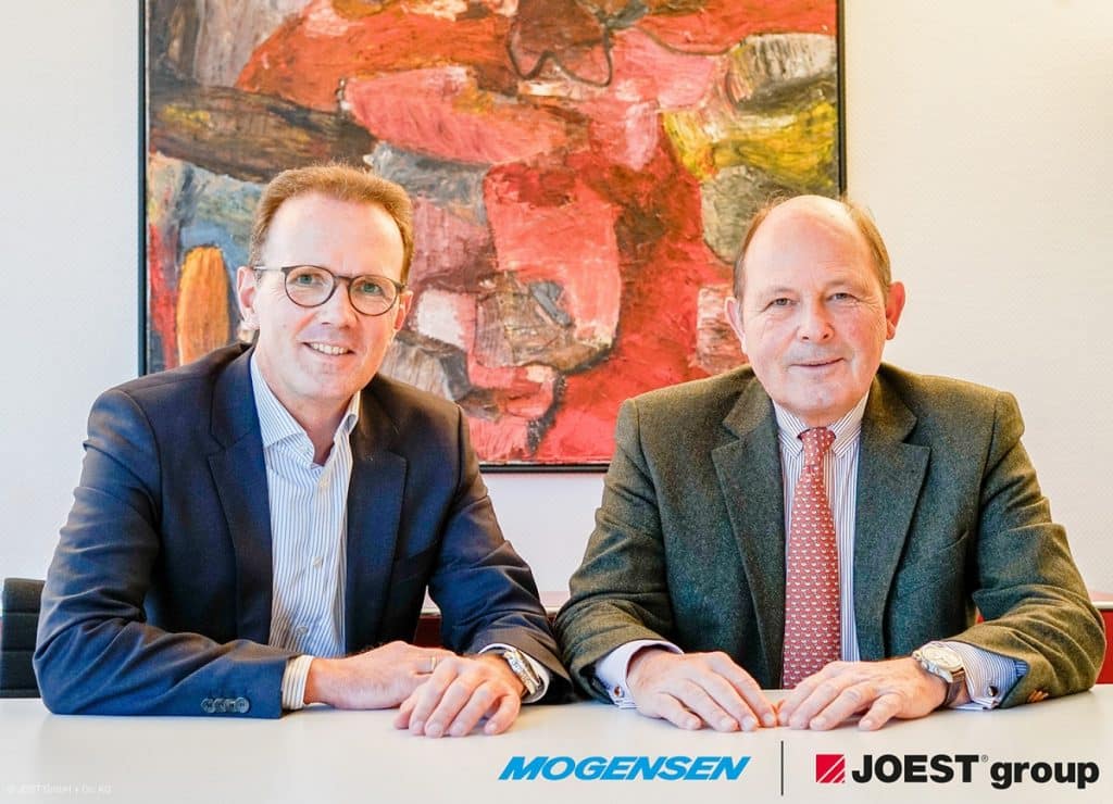 Dr. Marcus Wirtz und Dr. Hans Moormann, vor einem recht roten Bild an einem Tisch
