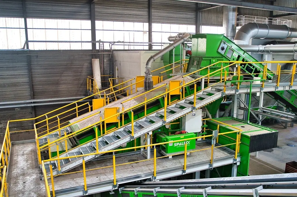 Zerkleinerungsmaschine in einer Industriehalle. Über zwei Etagen - Treppen und Abluftrohre.