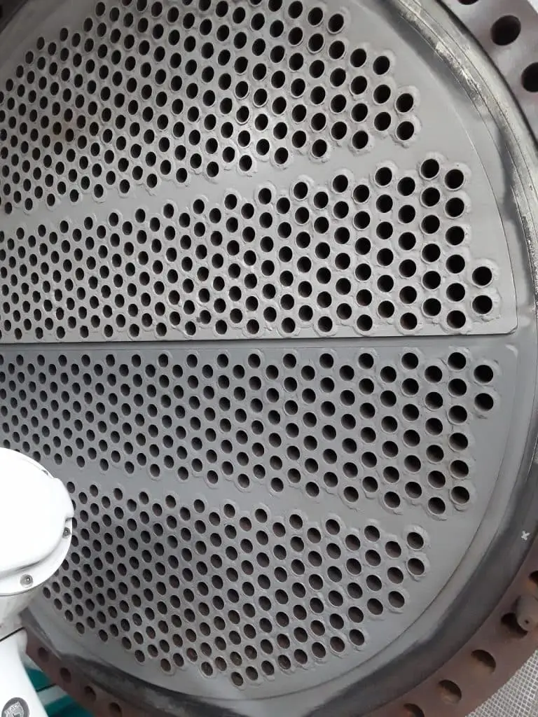 Zwei halbrunde leicht tiefe regelmäßig durchlöcherte Metallplatten, die zu einer kreisrunden Platte zusammengeschweißt wurden