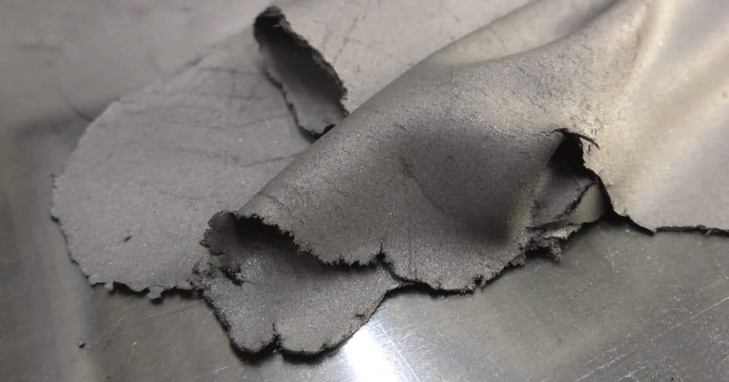 Trockener Elektrodenfilm aus strukturierter Mischung aufbereitet im Eirich-Mischer sieht aus wie ein graues leicht brüchiges Leder.