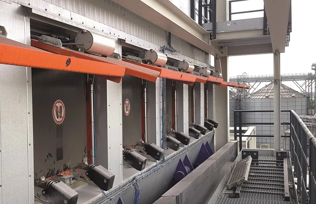 Druckentlastungsklappen auf dem Dach eines Industriegebäudes oder Silos, die im Hintergrund zu sehen sind.