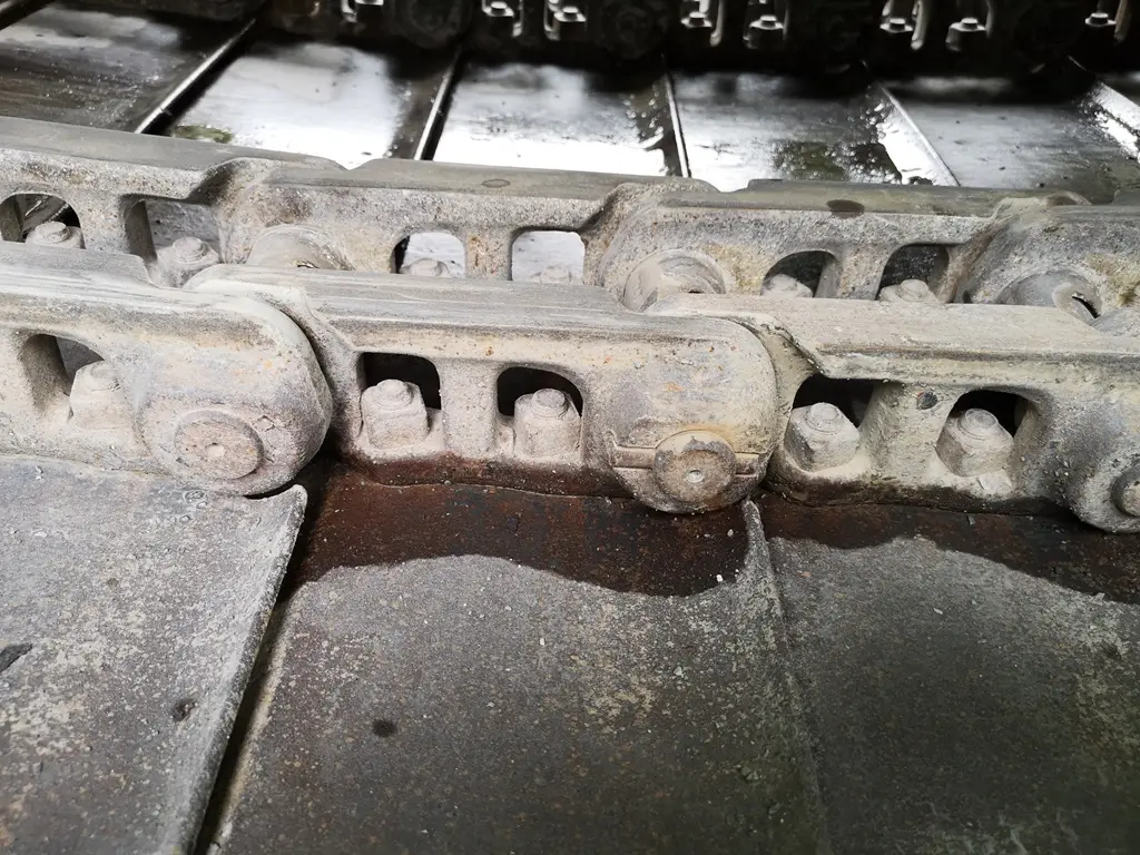 Dicke Kettenglieder und Rückführrollen und Elastomer-Kettenspanner.