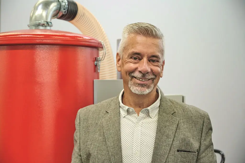 Klaus Gazawi der Ruwac Industriesauger GmbH vor einem Ausstellungsstück des Messestands der Solids 2024