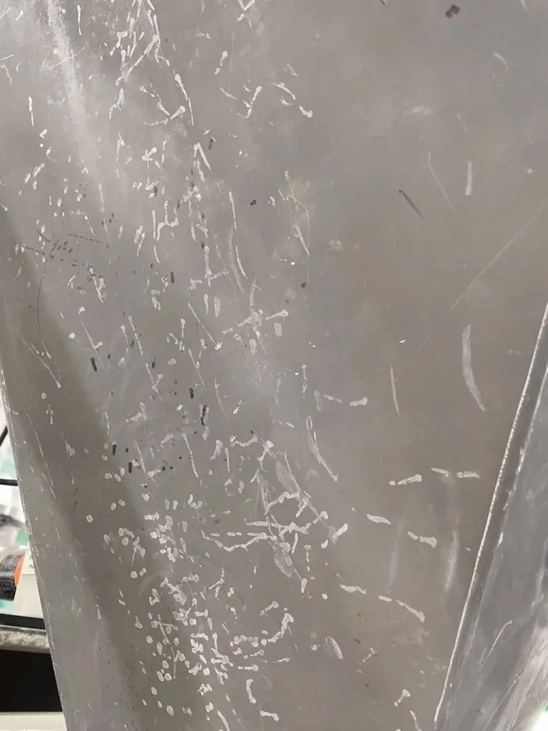 Metallfläche, die mit lauter Hammerschlägen beschädigt ist.