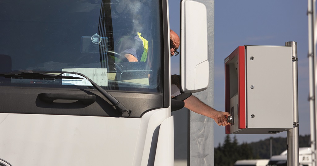 Lastwagenfahrer bedient ein Wägeterminal aus der Fahrerkabine.