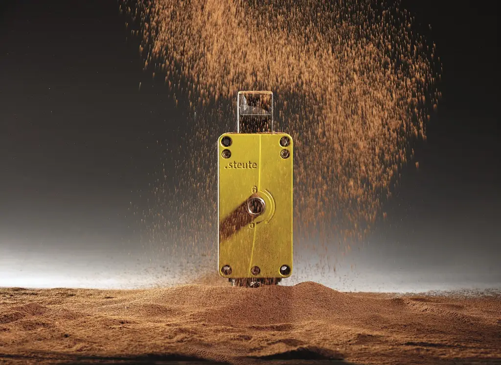 Sicherheitszuhaltungen auf Sand oder anderem pulverigen Untergrund. Ein bisschen davon ist vor dem Gerät in die Luft.