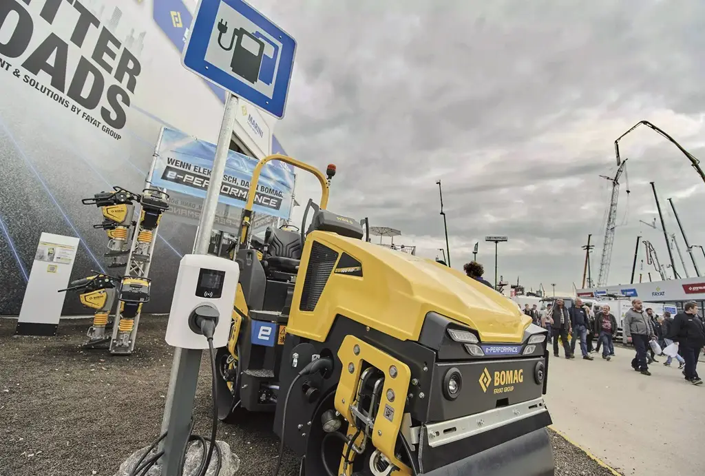 Außengelände der bauma 2024. Im Vordergrund eine Bomag Baumgaschine und eine elektro Ladestation