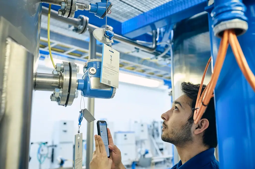 Mitarbeiter vergleicht die Daten auf dem Sensor mit den Daten auf seiner Mobiltelefon-APP