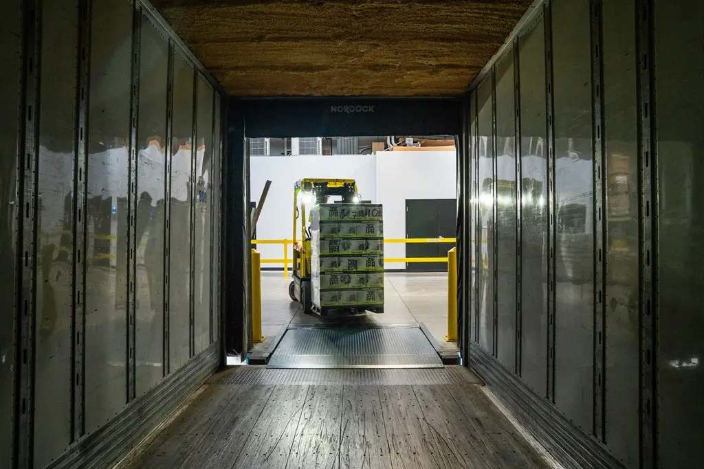Ein Container wird mit einem Gabelstapler be- oder entladen.