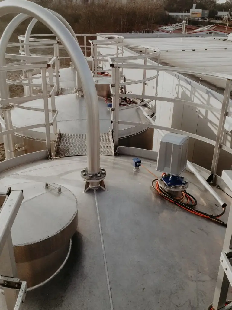 Blick von einem Silodach auf zwei weitere, verbundene Silos. Auf dem Silo sieht man Füllstandsmesser.