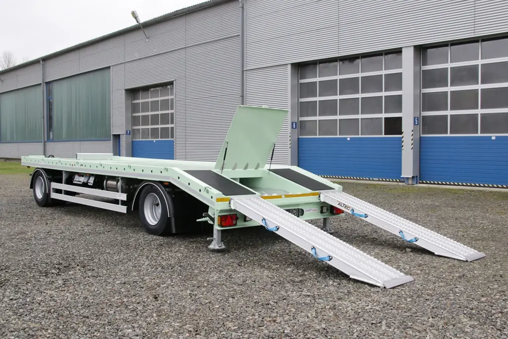 Lastwagen Anhäger mit Plateau für den Behälter Transport vor einer Industriehalle