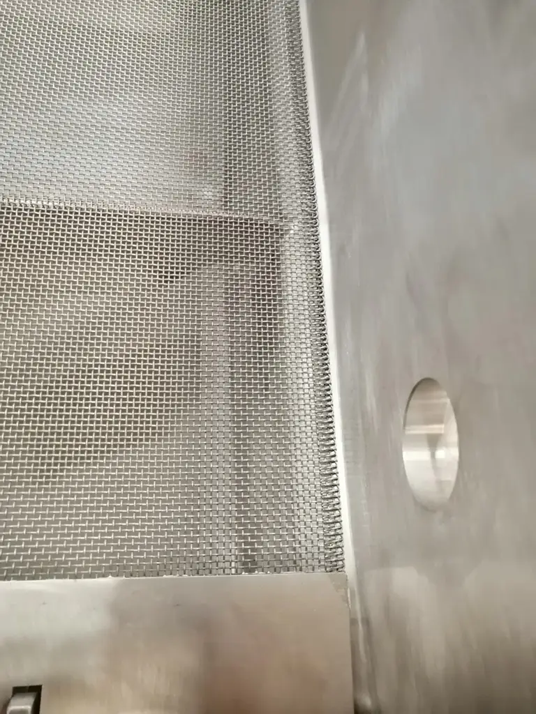 Blick in die Innenseite eines Industriesiebs. Glatte Seite mit Ablauf