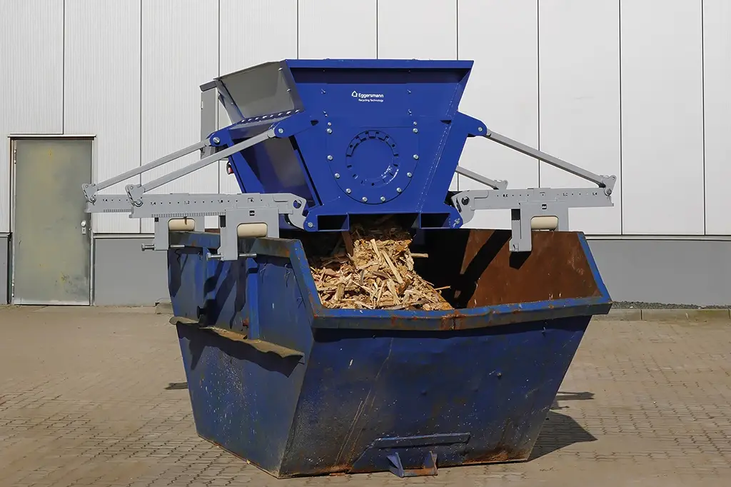 Zerkleinerer ist über ein flexibel einstellbares Halterungssystem auf einem Container fixiert.