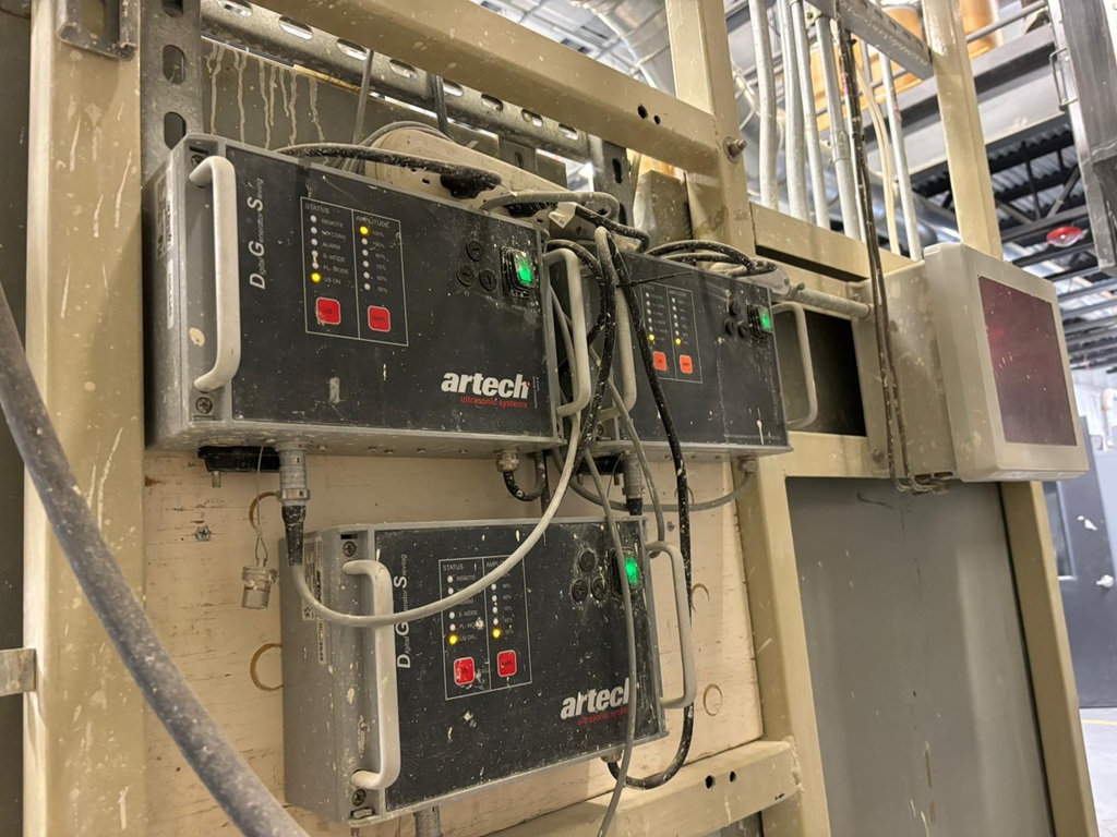 Schalttafeln von Ultrashallgeneratoren in einer Industriehalle an einer Wand.