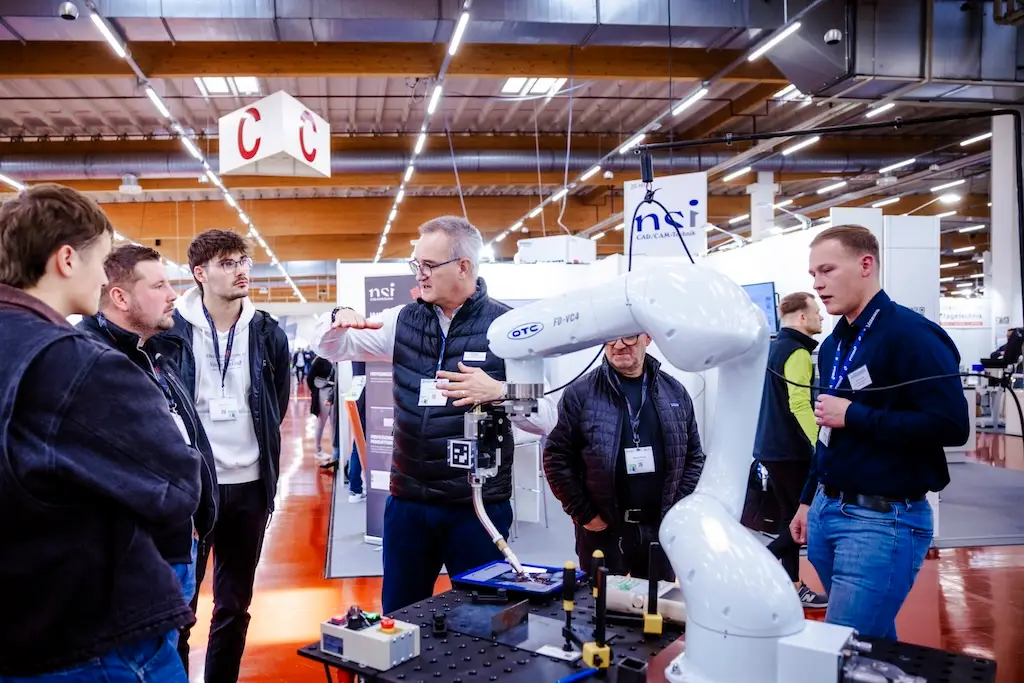 Firmenvertreter auf einer Messe unterhalten sich an einem Stand über Fachthemen
