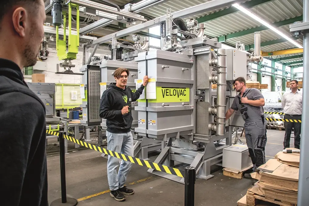 Mitarbeiter der Greif-Velox präsentieren einen Velovac auf einer Industrie-Veranstaltung in der Produktionshalle