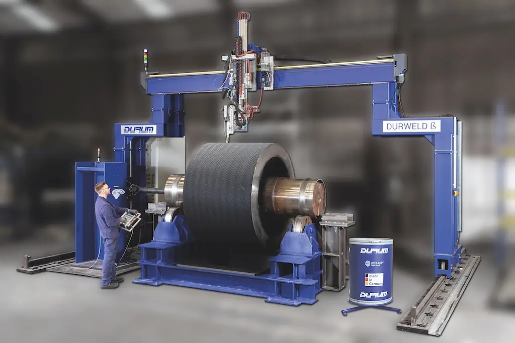 Groe industriemaschiene mit blauen Metalleilen. ein Mann steht davor