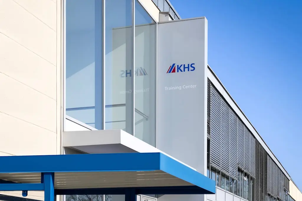 Weißes Gebäude mit Glasfront und der Aufschrifft KHS Training Center