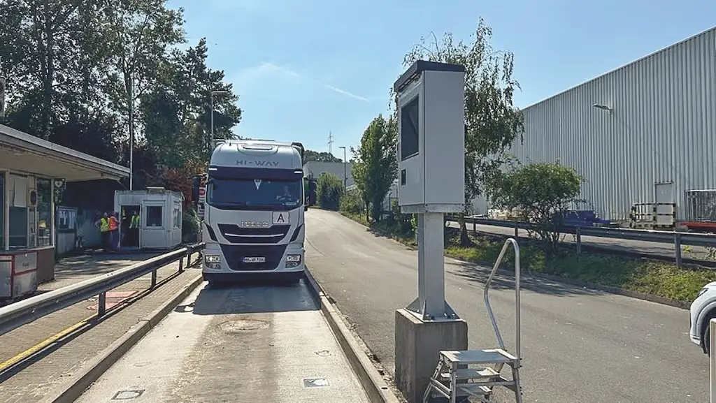 LKW steht neben Häuschen mit Arbeitern