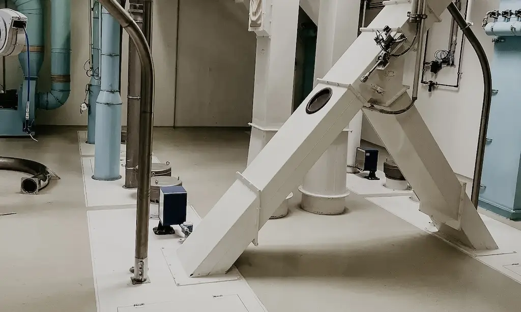 Beige und blau gestrichener Industrieraum mit Rohren und Schächten.