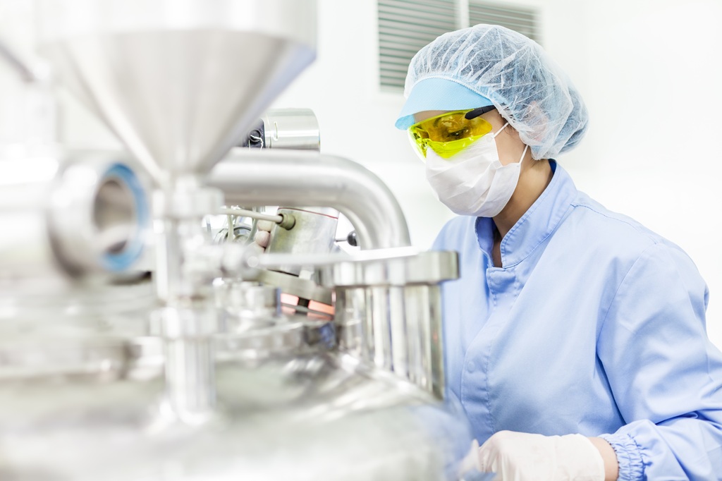 Mitarbeiterin steht vor Labormaschine Avatar_023 shutterstock.com