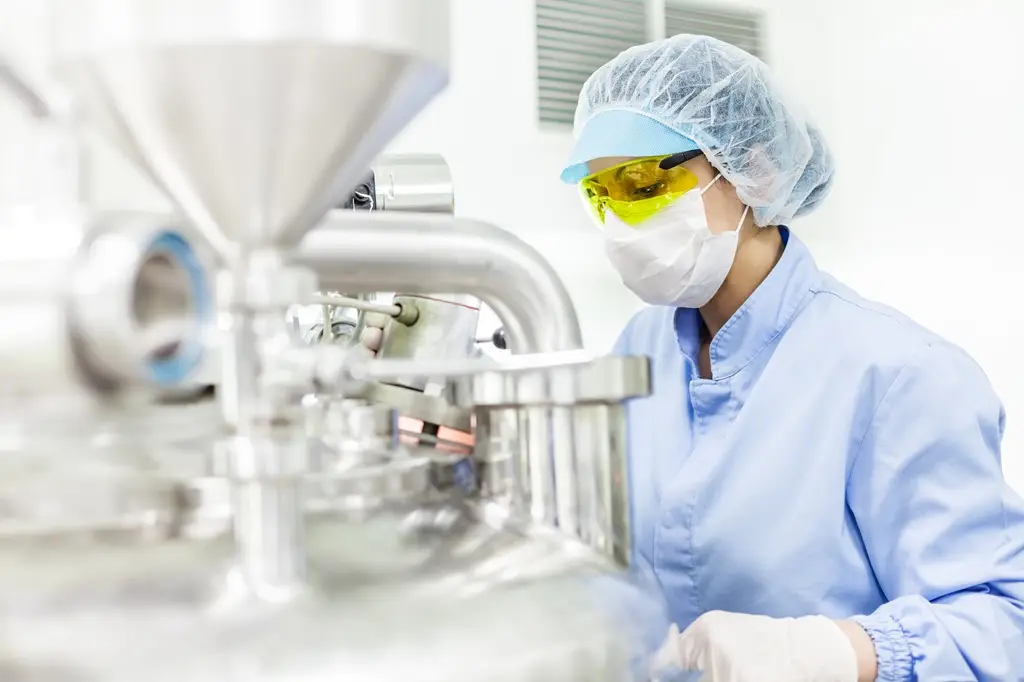 Mitarbeiterin steht vor Labormaschine Avatar_023 shutterstock.com
