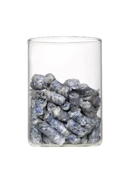 Ein Laborglas, in dem blaugraue pelletierte Folienreste liegen.