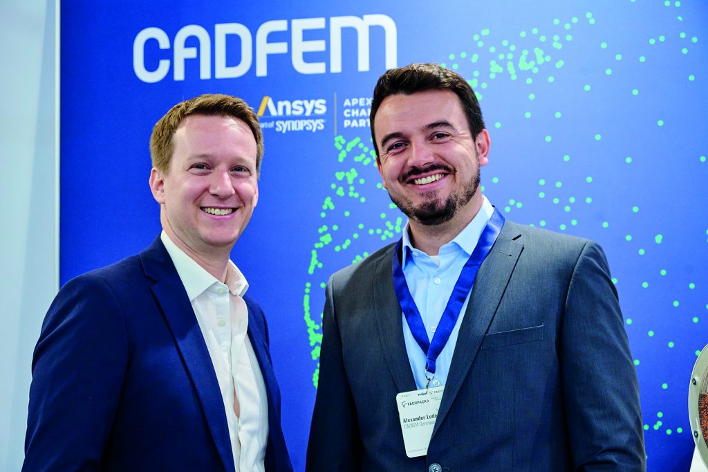 Maxililien Dufis und Alexander Ludewig beide Mitarbeiter der Cadfen, stehen am Messestand der Powtech Technopharm 2025