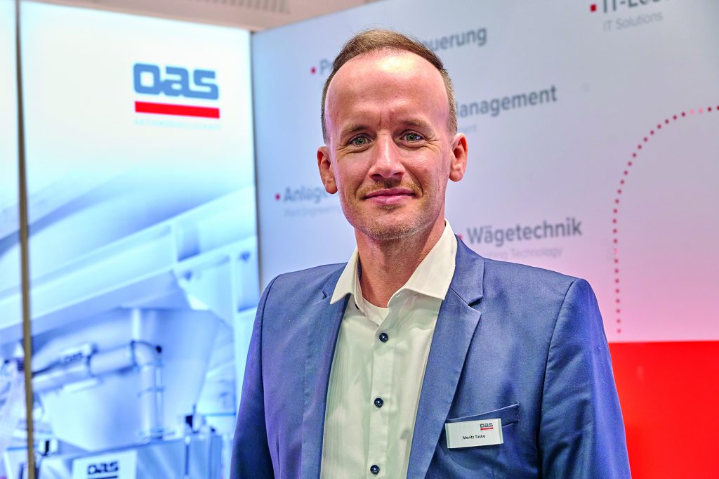 Moritz Taske, Mitarbeiter der OAS steht am Messestand der Powtech Technopharm 2025